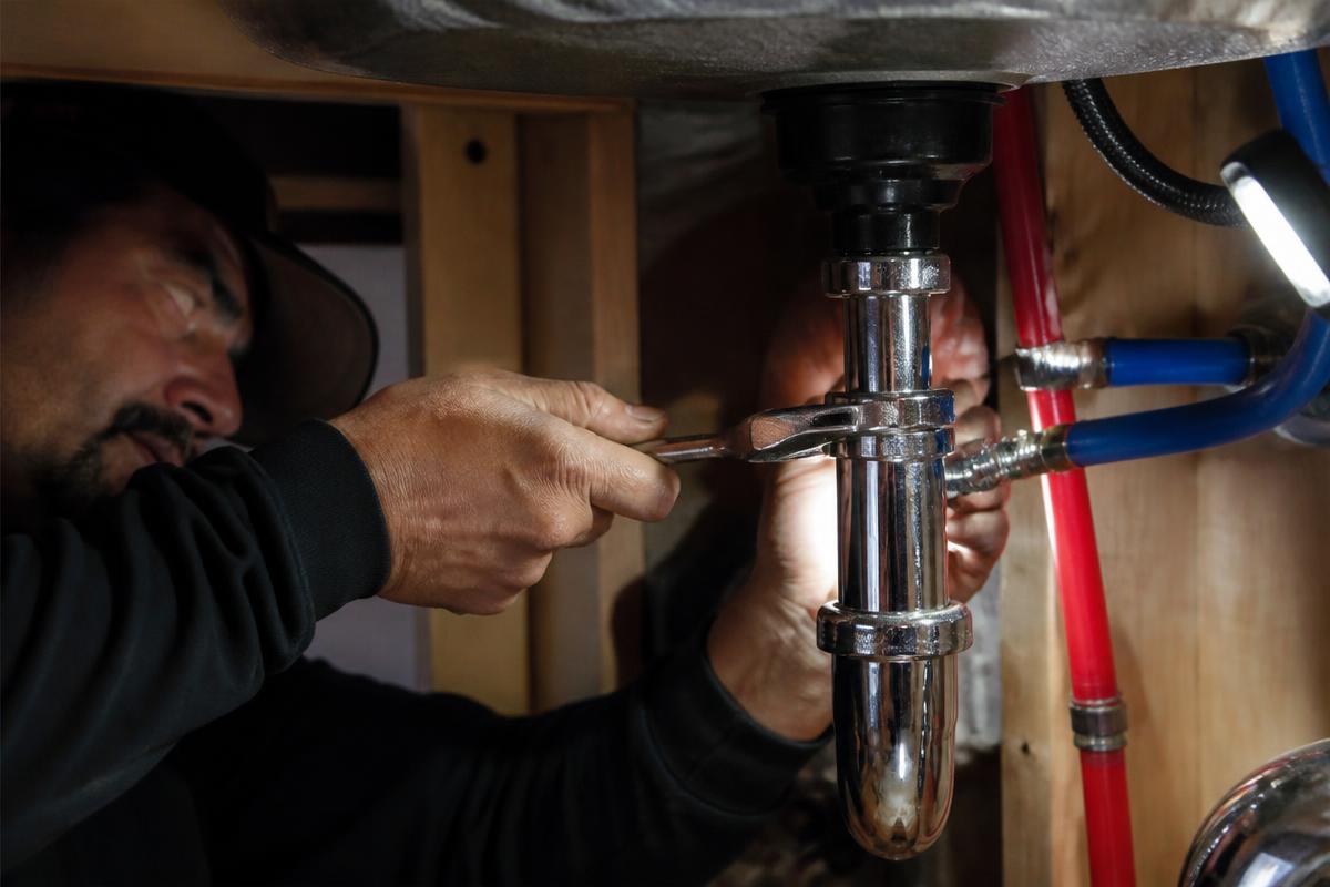 Profissional em execução de canalização durante remodelação